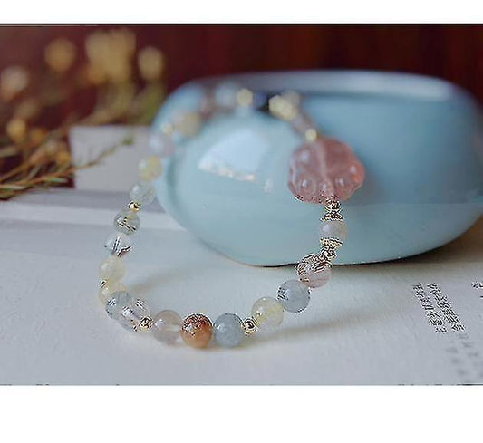 Light pink and clear bead bracelet with dangling charm and chain tassels
