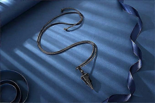 Crystal pendant necklace laid flat: black pointed stone on braided rope cord