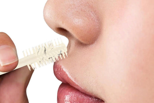 Nose hair trimmer comb tip held near nose for trimming