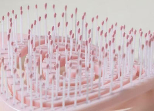 Pink spiral hair massage comb close-up of bristle tips