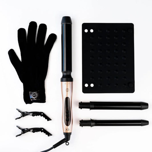 Rose gold curling wand with black barrel attachments, safety gloves, and heat pad