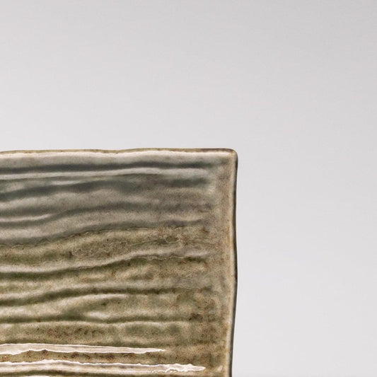 Rectangular ceramic plate rim with sage green textured glaze and speckled finish