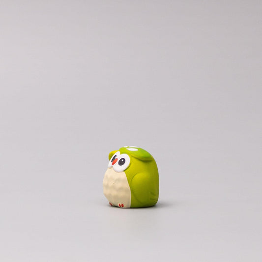 Green owl figurine side view with white belly and red feet