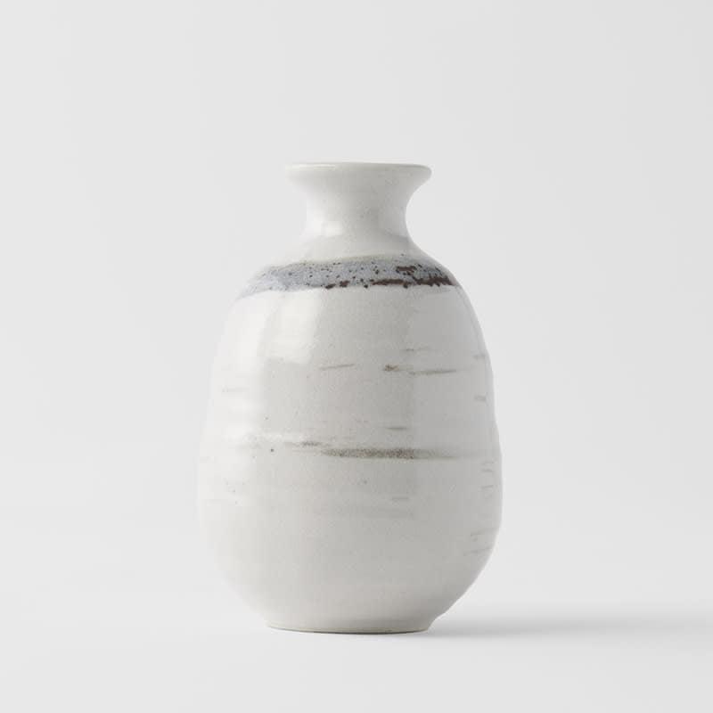 White glazed sake jug with dark speckles and faint horizontal stripe across body