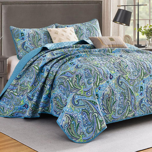 Quilt coverlet set with layered blue-green paisley bedding and extra throw pillow