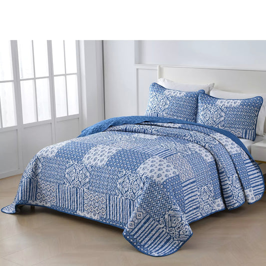 Quilted bedspread draped on a queen bed with blue-and-white patterned pillow covers