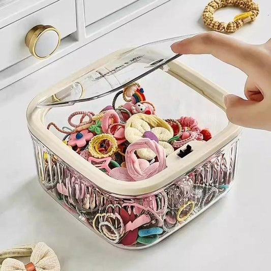 Transparent storage box filled with mixed hair accessories, including bows and elastic ties.