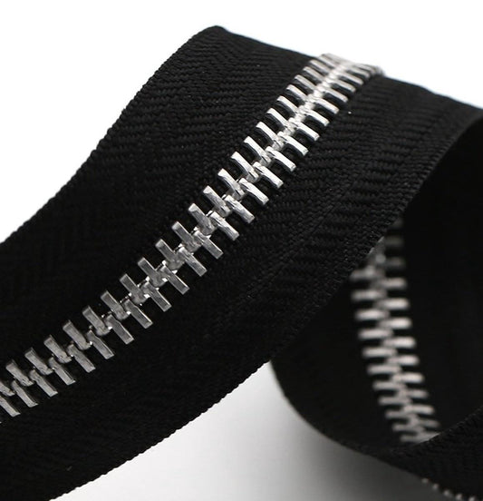 Black zipper tape with silver metal teeth, close-up