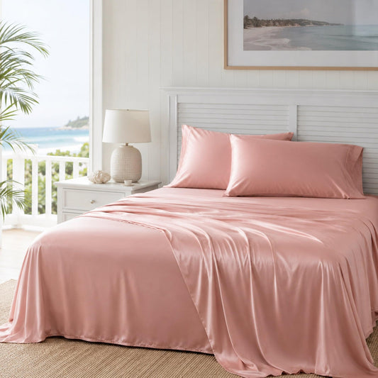 Coral pink bamboo sheet set on bed with matching pillow and fitted sheet