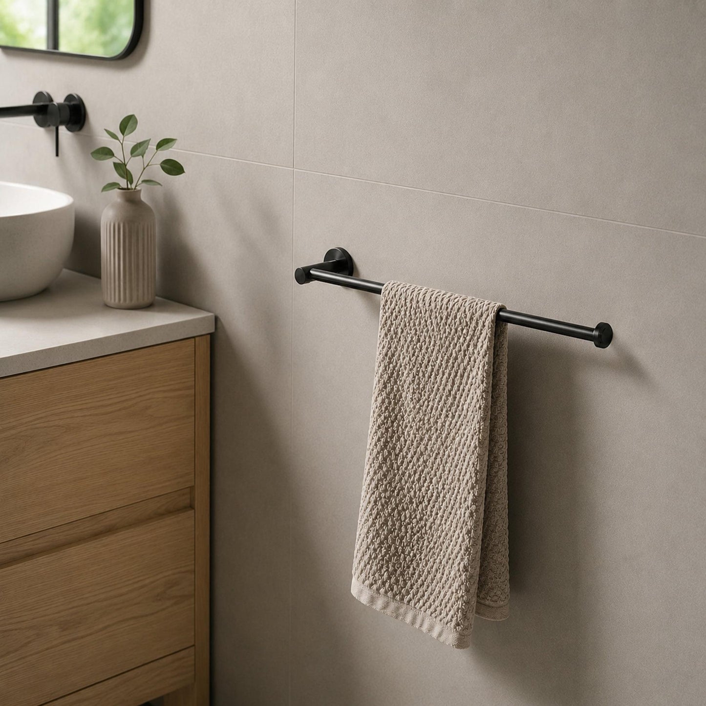 Matte black towel holder bar with round end caps; beige hand towel hanging