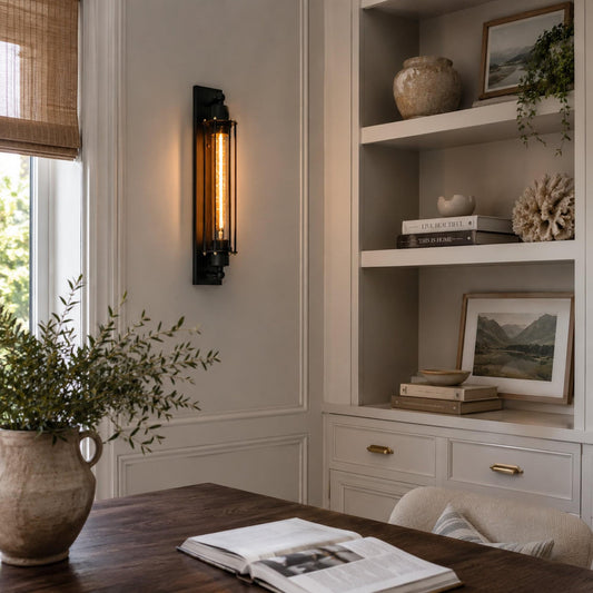 Black wall-mounted sconce lamp with glowing filament tube in glass cage
