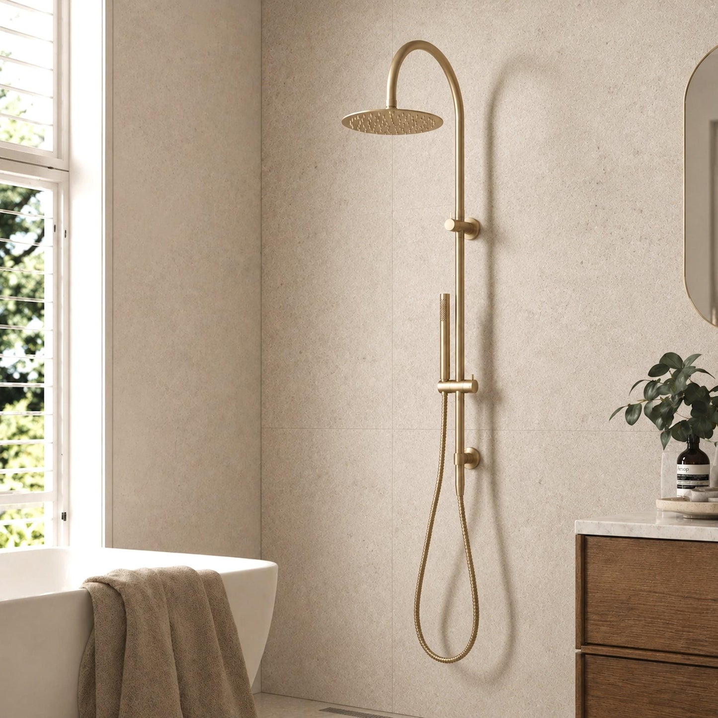 Brushed brass wall shower with overhead rain head, handheld outlet, and hose