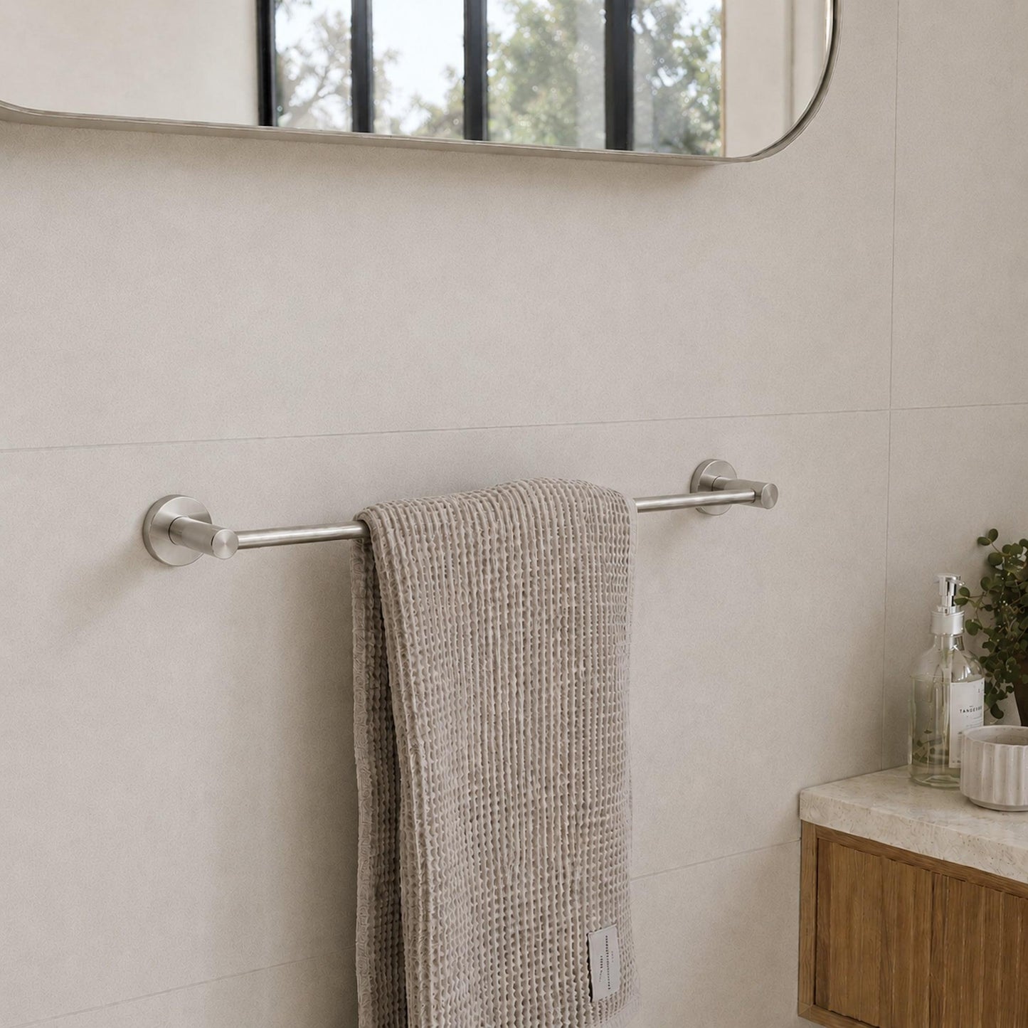 Brushed nickel single towel rail with a towel draped over the bar