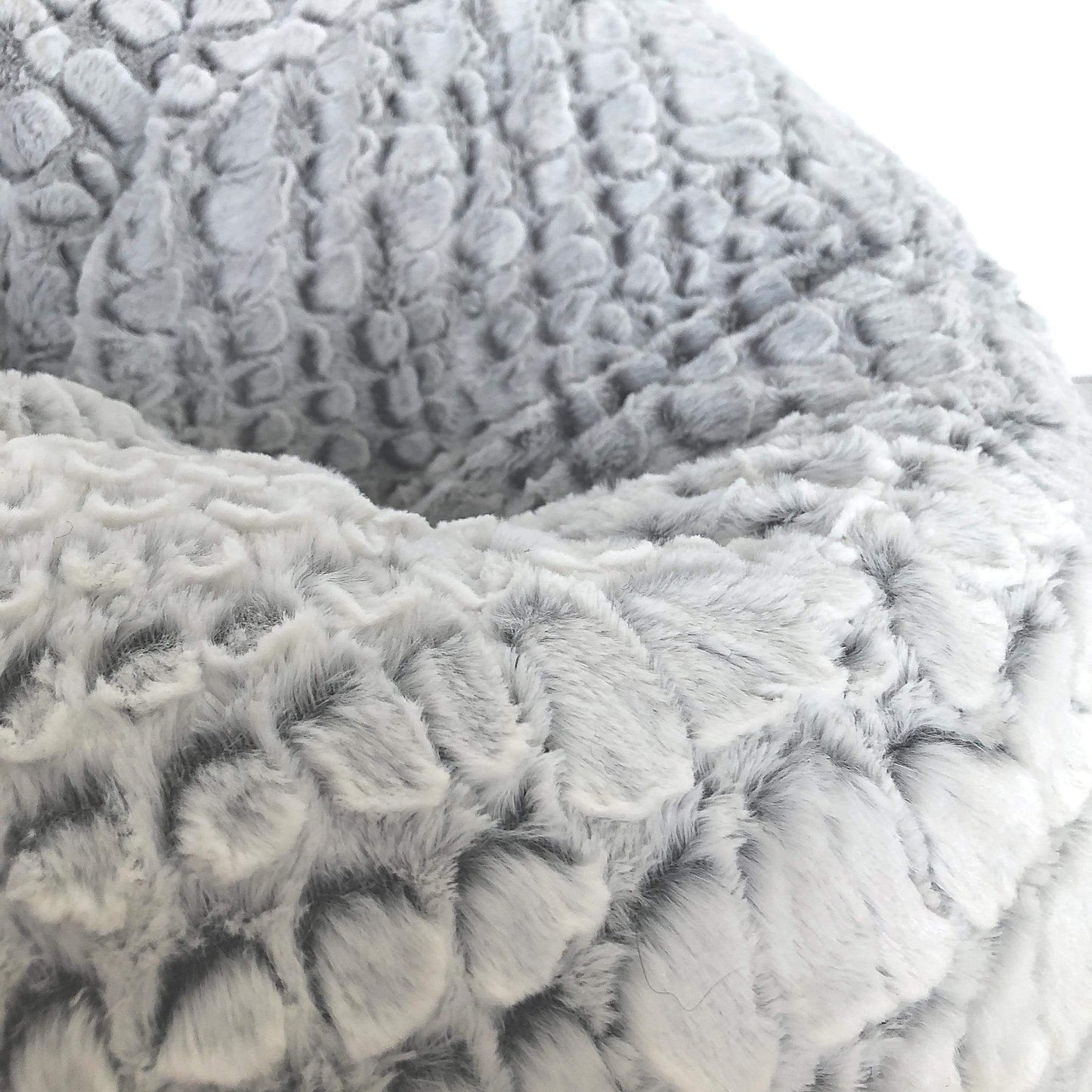 Close-up of light gray plush, raised patterned cashmere fabric