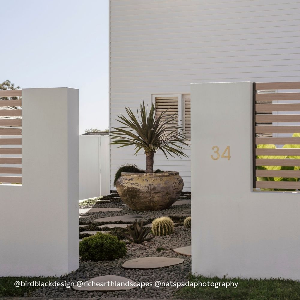 Exterior house number plaque 34 on white stucco wall