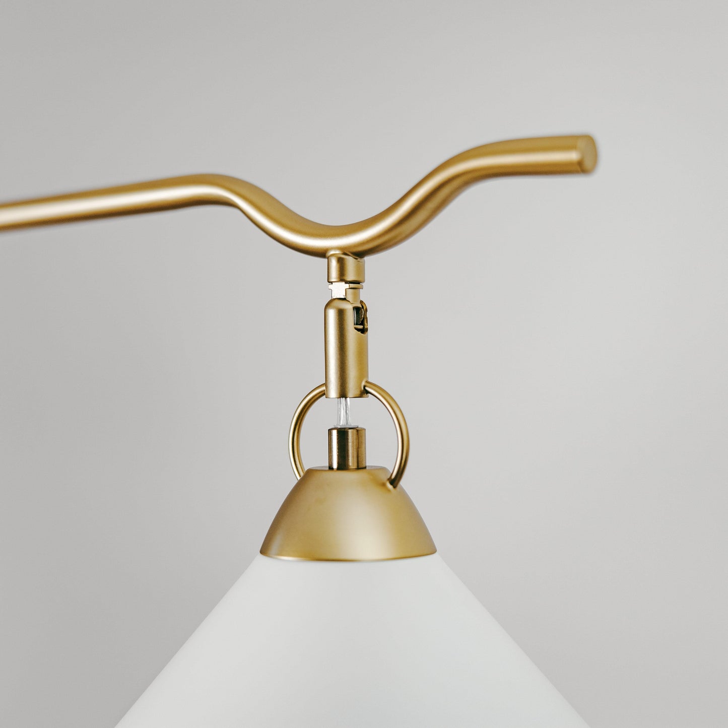 Gold metal cone pendant shade with curved arm and hanging ring