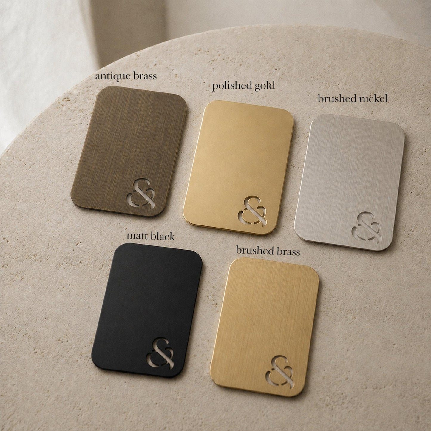 Set of six metal color swatch cards with ampersand emblems in brass, gold, nickel