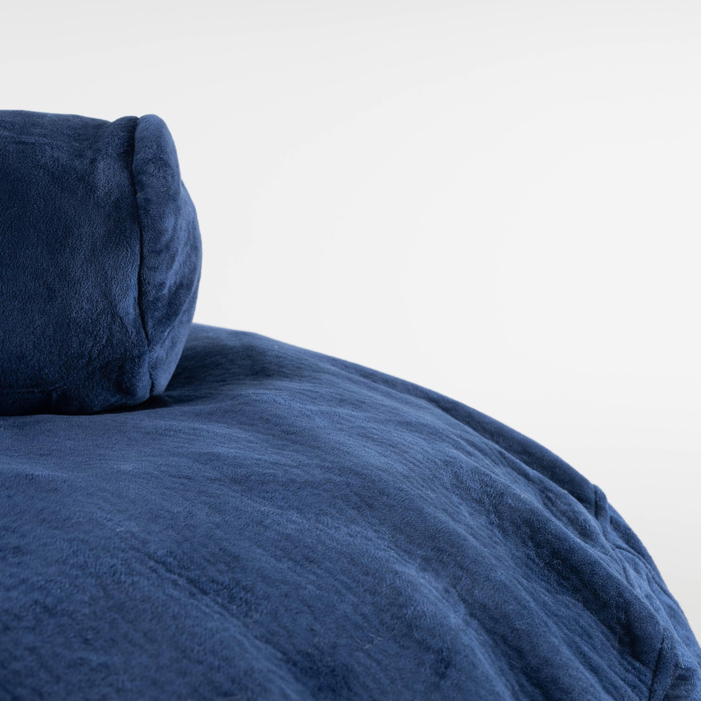 Navy plush cushion with visible seam and rounded corner