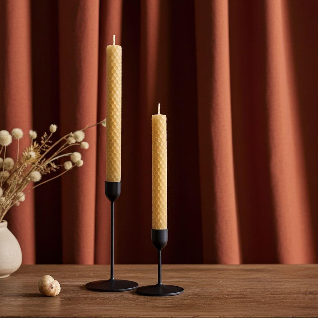 Two hand-rolled beeswax taper candles with black holders
