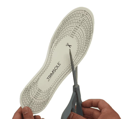 Beige memory foam insole with cut-to-size trim markings, held for trimming
