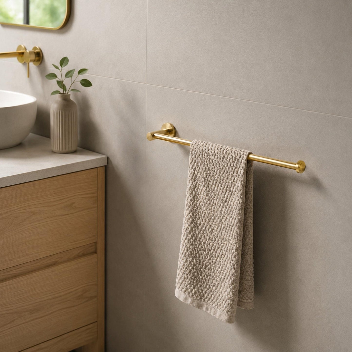 Polished gold hand towel holder with towel on bar and round wall mount
