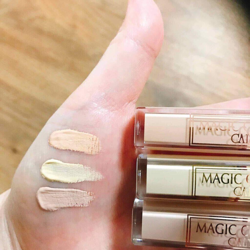 Hand swatches of three concealer shades beside clear concealer tubes