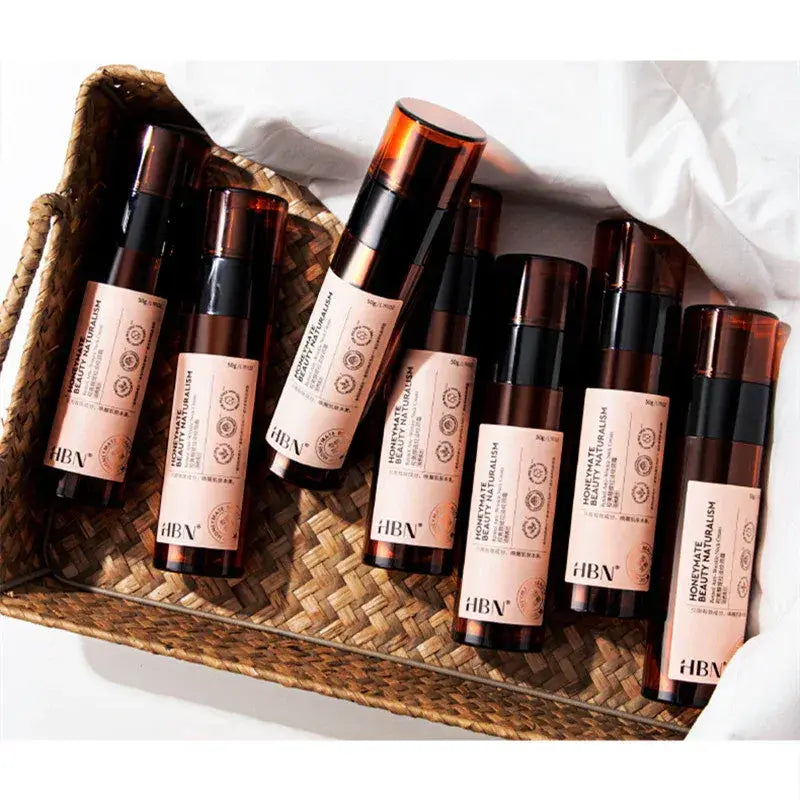 Group of HBN essence lotion bottles with black pumps in woven tray