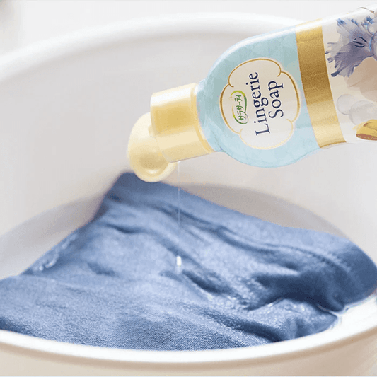 Lingerie soap dispenser pouring onto blue fabric