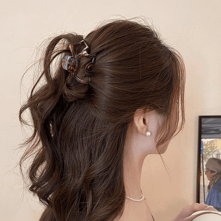 Dark tortoiseshell hair claw securing brown hair in a half-up style