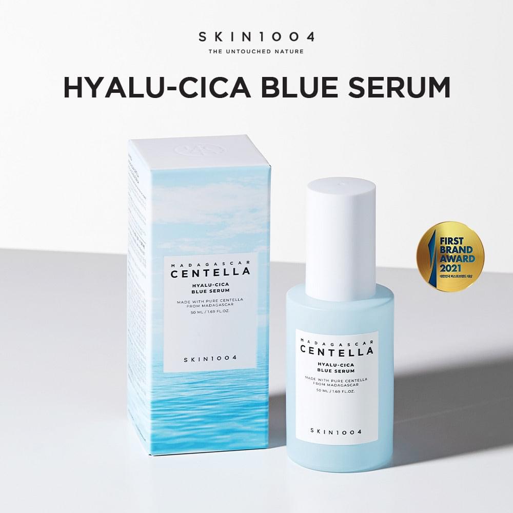 Light blue serum bottle with white cap beside matching box and award badge.