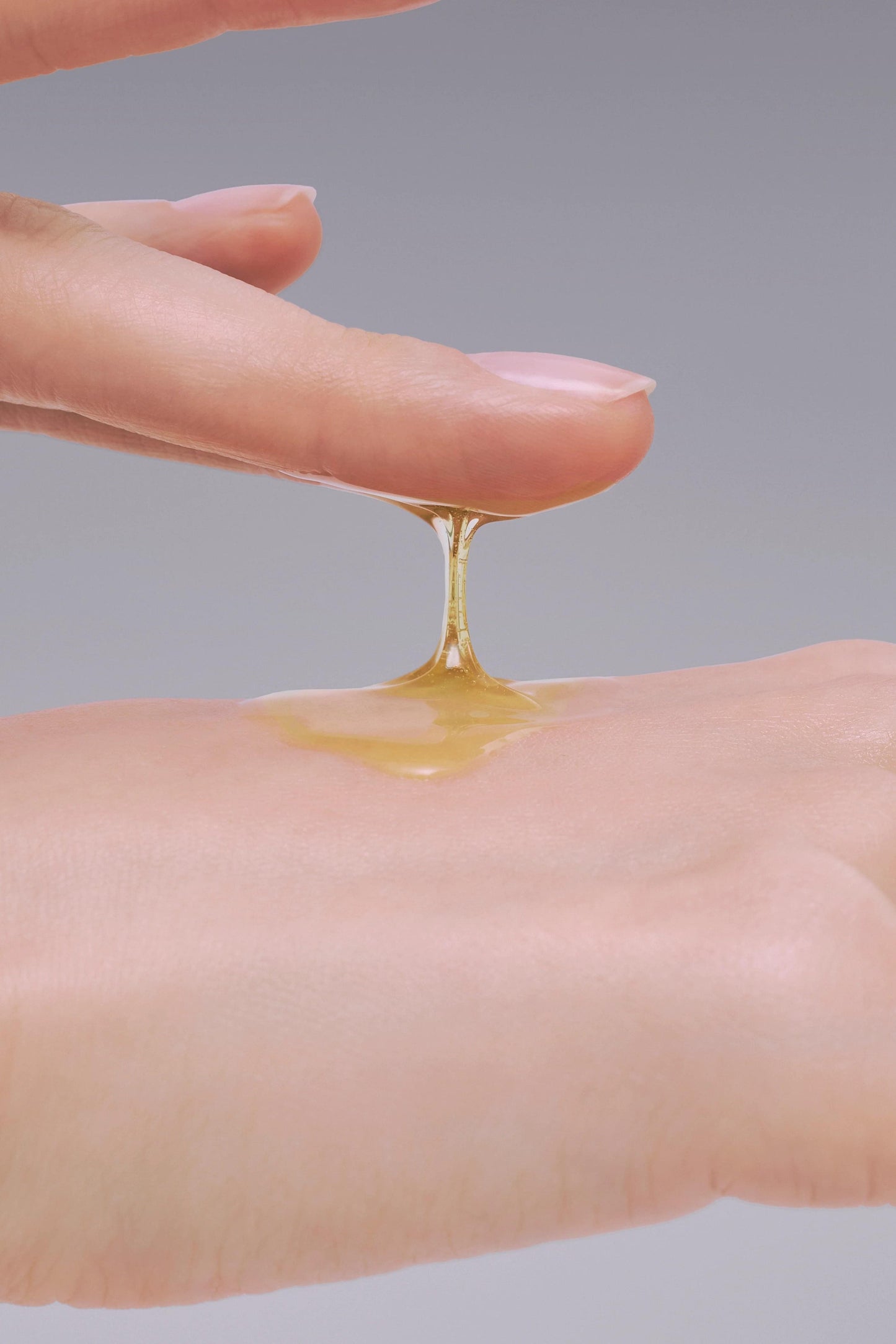 Gold silk hair oil drop on open palm