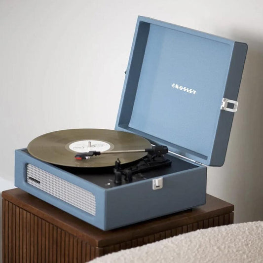 Washed blue Crosley portable turntable with spinning vinyl record and open lid