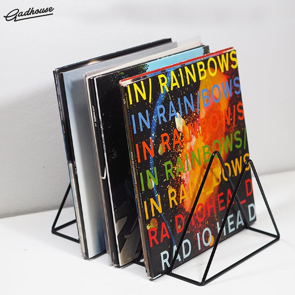 Black metal vinyl rack displaying stacked records with colorful cover art