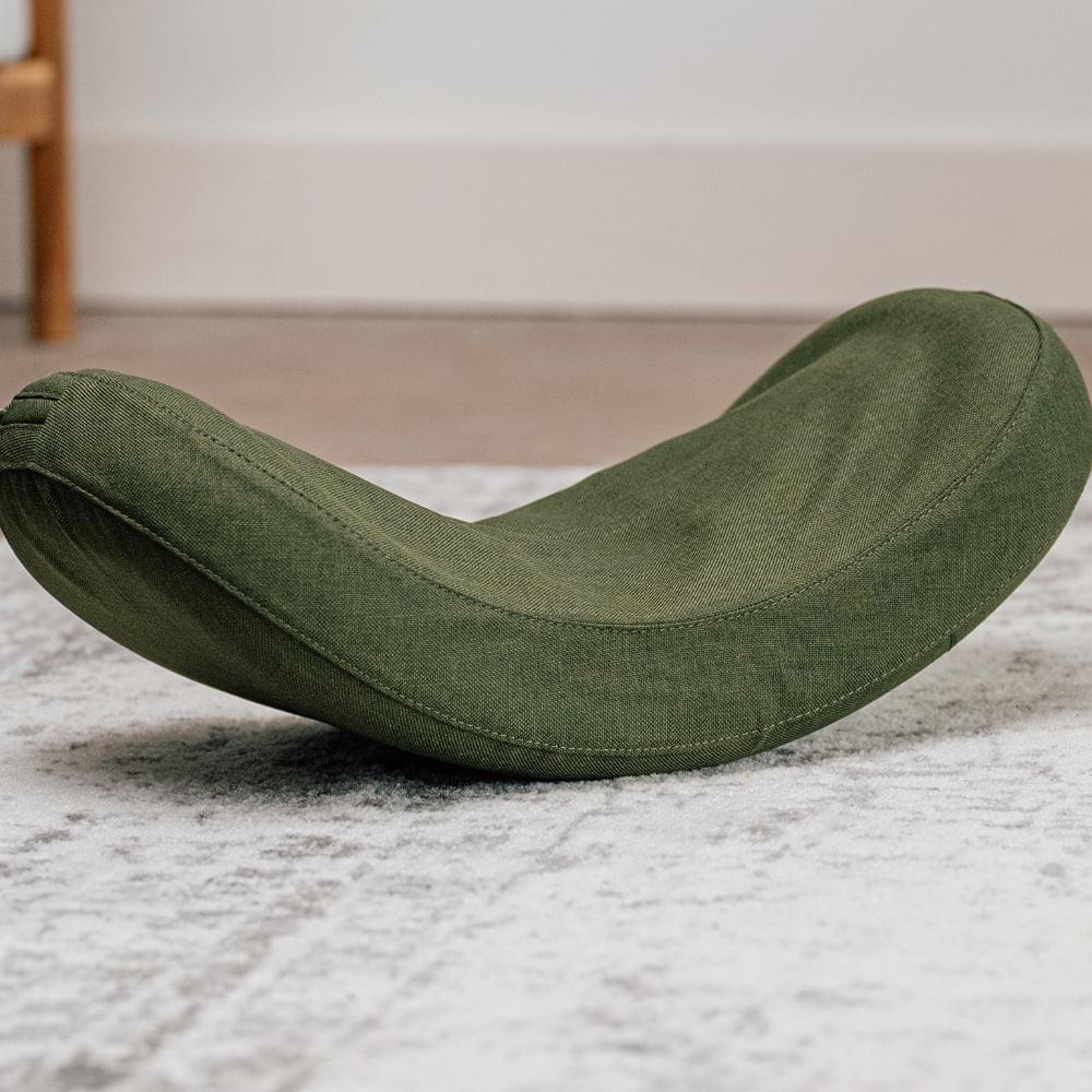 Olive-green lumbar massage stretcher on floor, curved support angled upward