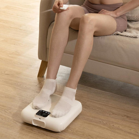 HALO Percussion foot massager in use with socked feet on white platform