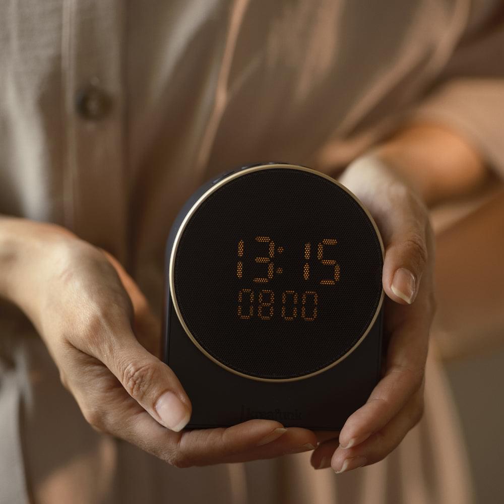 Black alarm clock with Bluetooth speaker, circular display showing 13:15