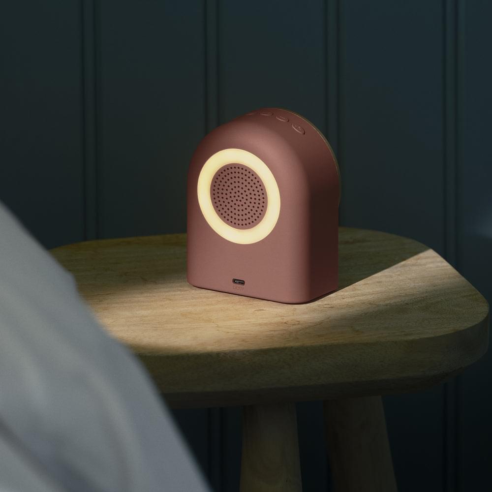 Terracotta alarm clock speaker in angled view with round speaker grille