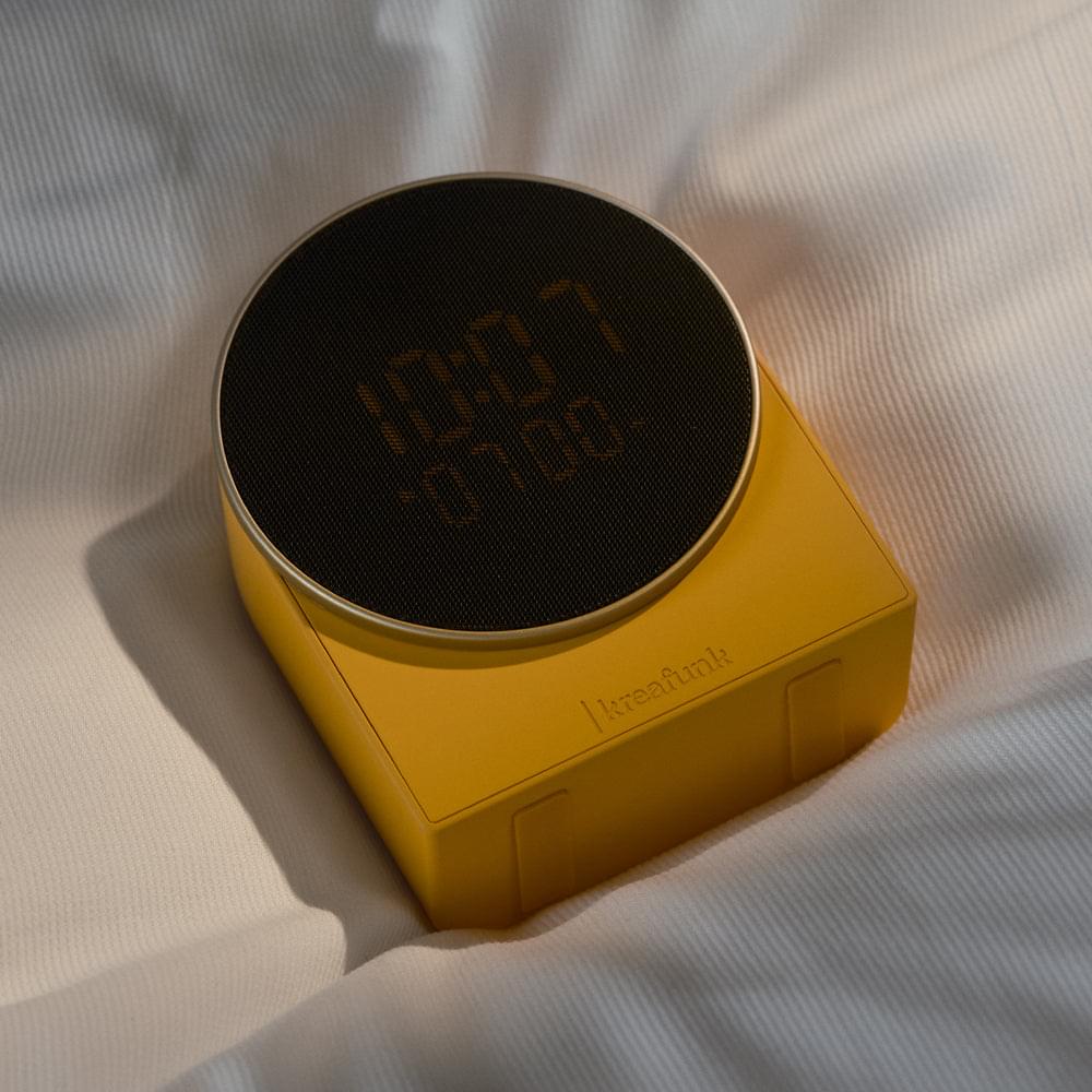 Kreafunk alarm clock with Bluetooth speaker in mango burst, top view with round grille display