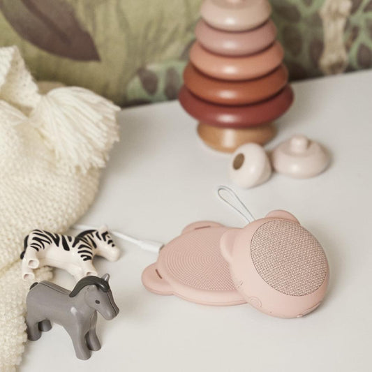 Dusty rose bear-shaped Qi wireless charger lying on side, perforated face