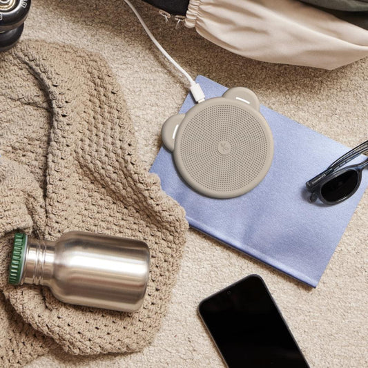 Ivory wireless Qi charger puck with perforated top, ear handles, and charging cable