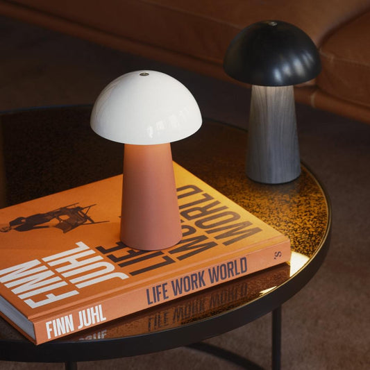 Terracotta base table lamp with white dome shade beside dark mushroom lamp