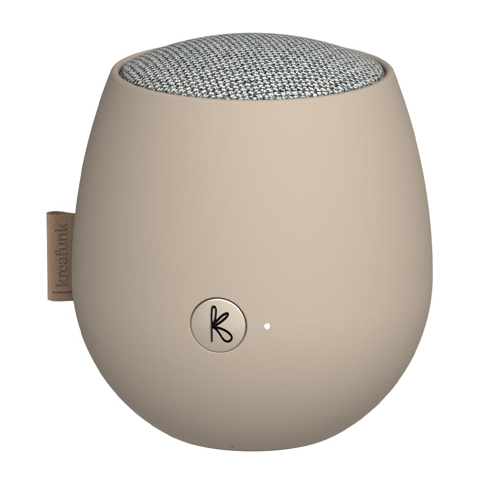 Ivory sand Bluetooth speaker with fabric top and circular K logo on front