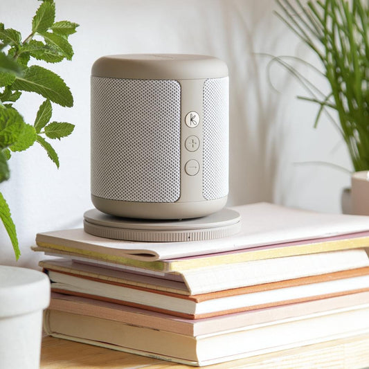 Ivory cylindrical Bluetooth speaker with side control buttons and fabric mesh grille