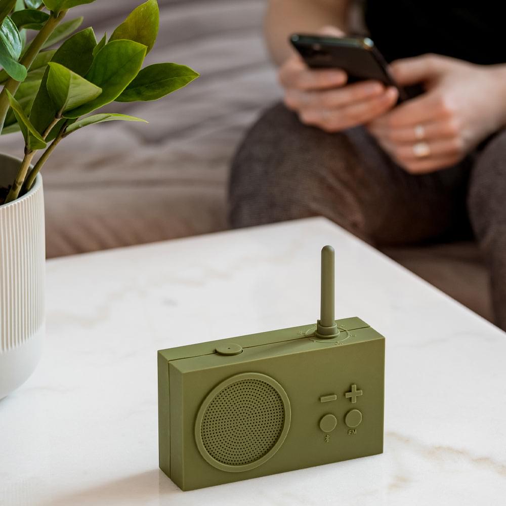 Khaki portable radio and Bluetooth speaker on table with antenna upright