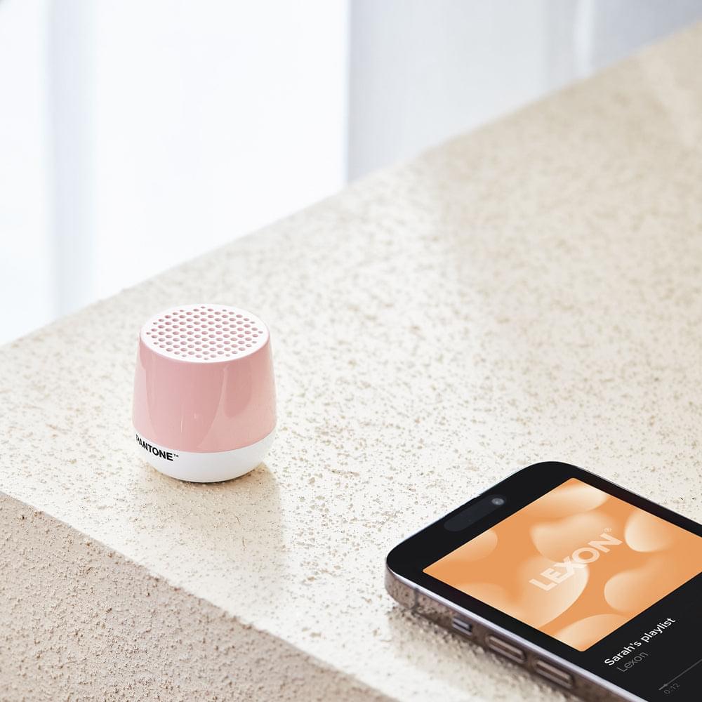 Rose pink mini Bluetooth speaker with perforated top grille and PANTONE logo