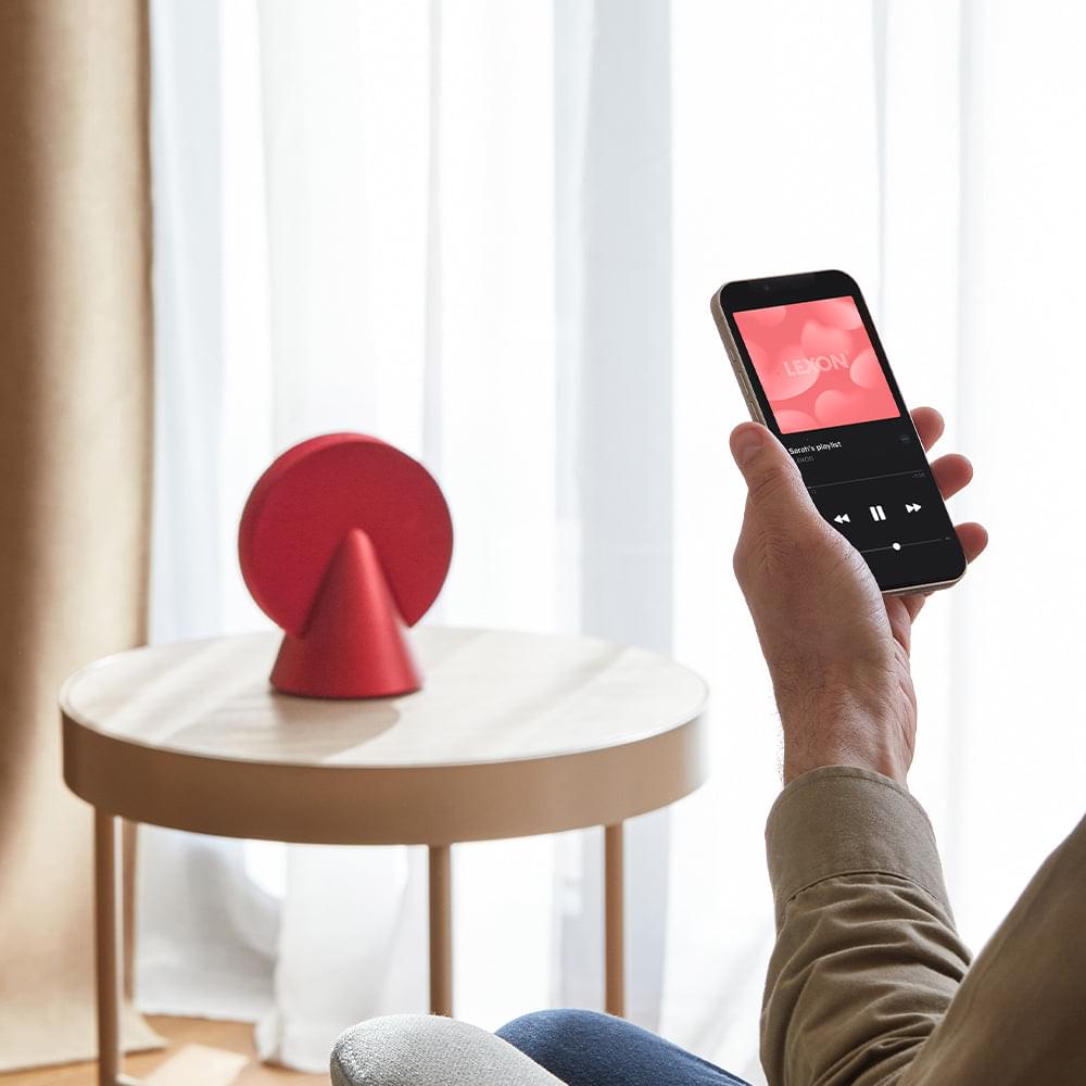 Red conic Bluetooth speaker on a round white stool