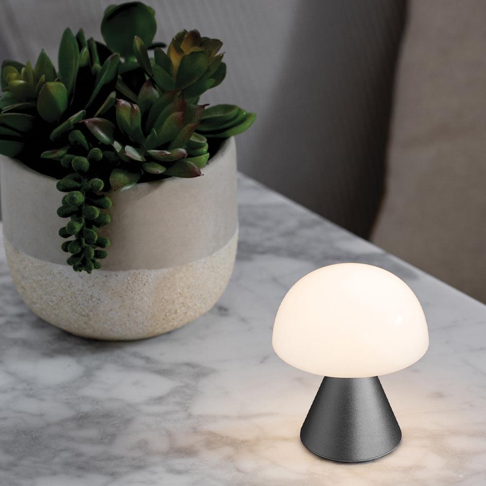 Mini LED table lamp with frosted white dome and dark base on tabletop