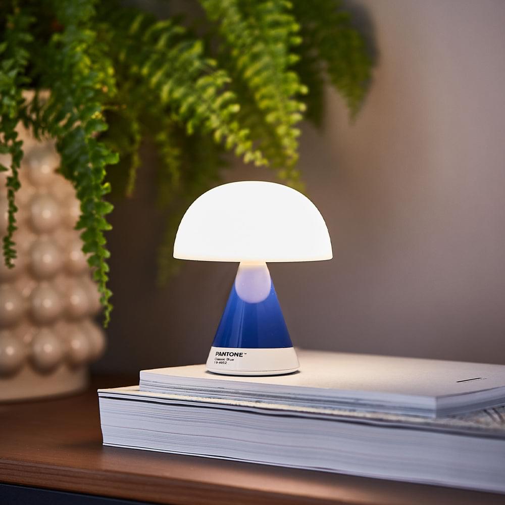 Portable LED lamp with white dome shade and blue stem, white base with Pantone label