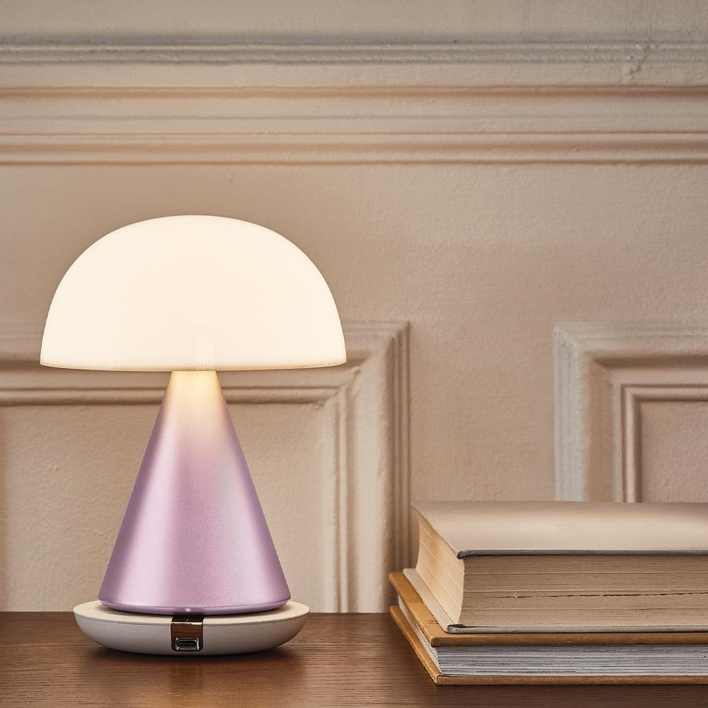 Portable LED lamp with glowing translucent dome and pink metallic base