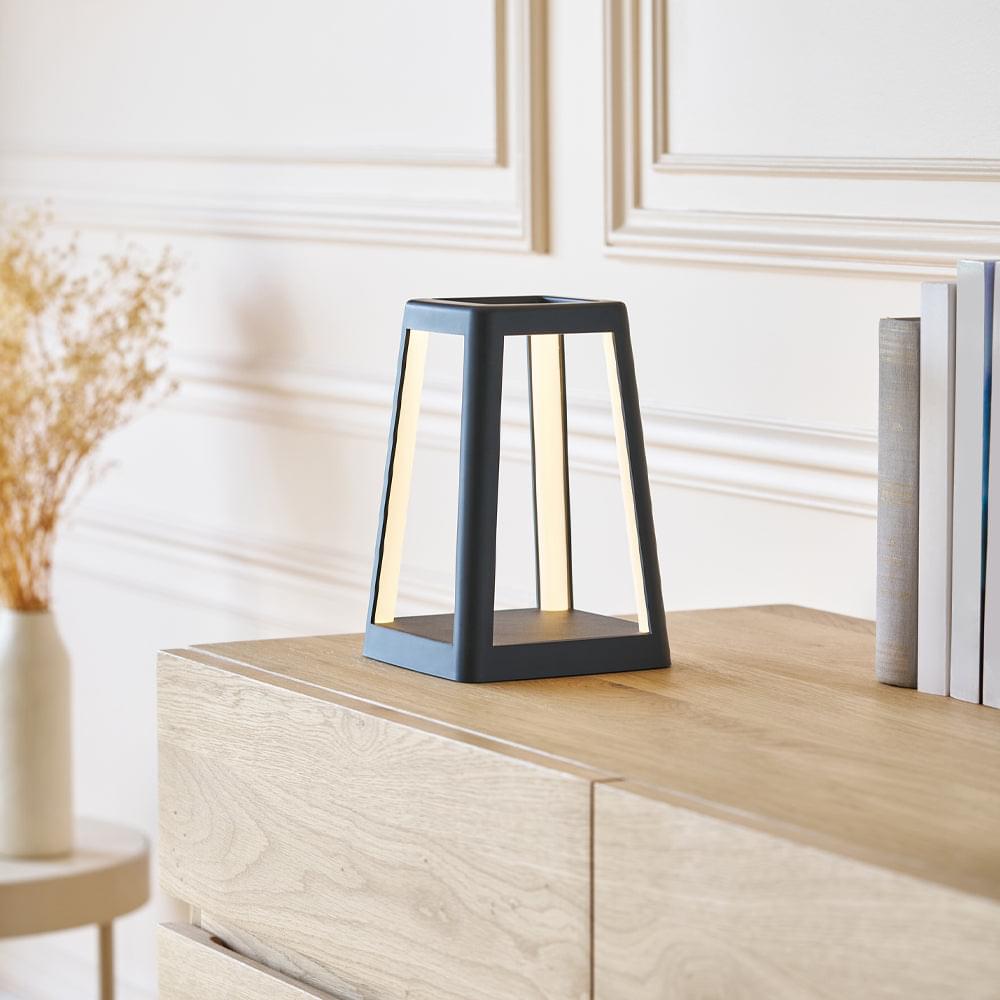 Black portable lantern lamp on tabletop with open frame and inner tube